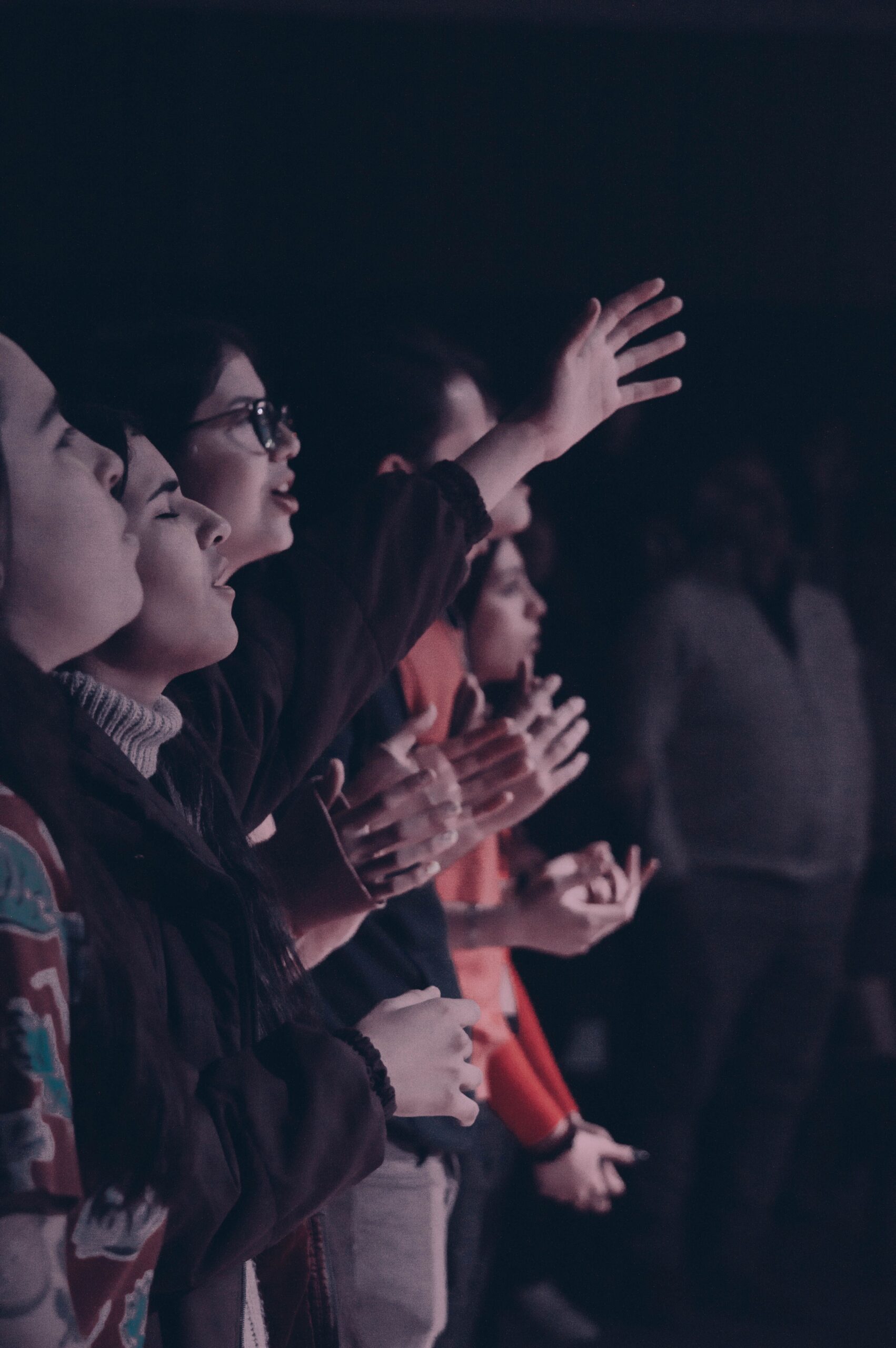 A group of people participating in a worship event with hands raised, captured in Mendoza, Argentina.